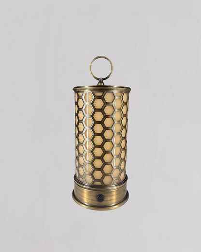 Decorative brass lantern with honeycomb pattern on a light gray background