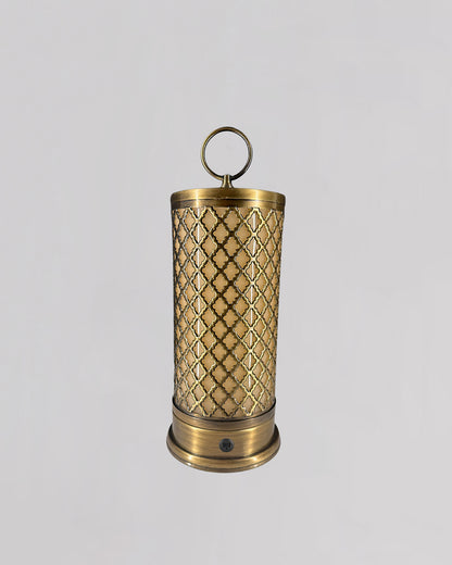 Decorative brass candle holder with intricate patterns on a light gray background