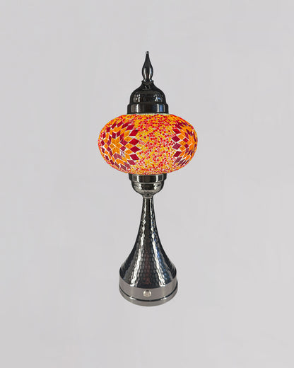 Decorative table lamp with a colorful glass shade on a gray background