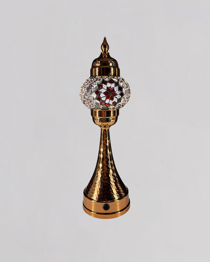 Decorative object with gold and crystal design on a gray background