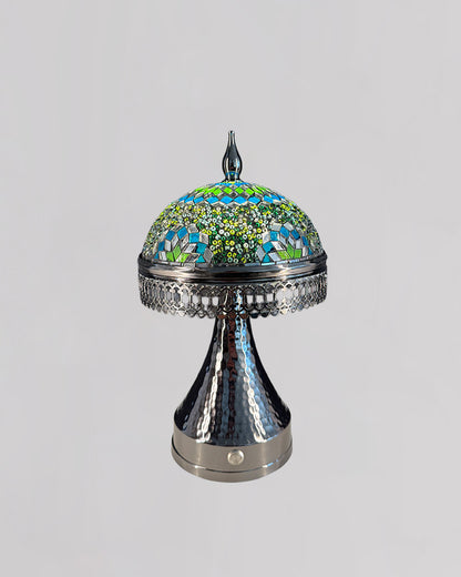 Decorative lamp with mosaic top and metallic base on a light gray background