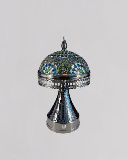 Decorative lamp with mosaic top and metallic base on a light gray background