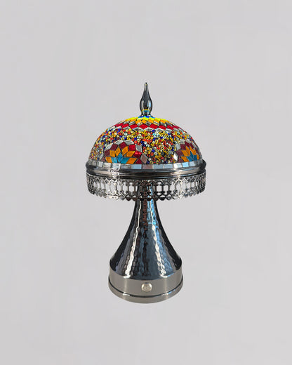 Decorative lamp with colorful mosaic top and metallic base on a gray background