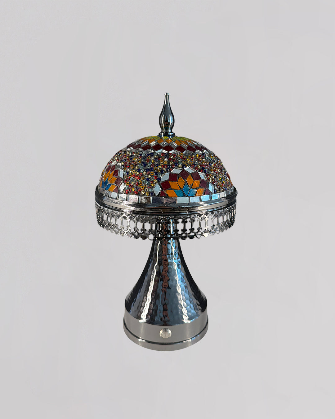 Decorative lamp with mosaic top and metallic base on a light gray background