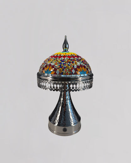 Decorative lamp with colorful mosaic top and metallic base on a light gray background