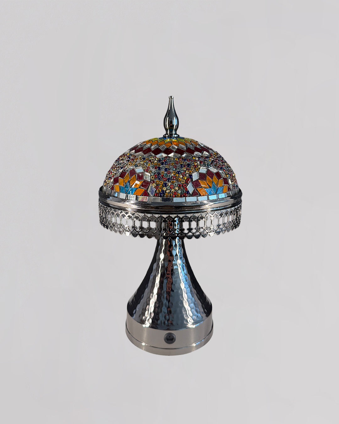 Decorative lamp with mosaic top and metallic base on a light gray background