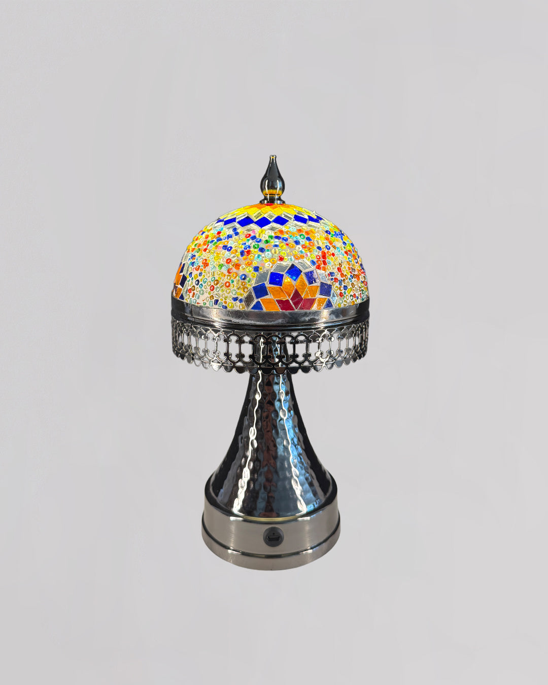 Decorative object with colorful mosaic top and metallic base on a light gray background
