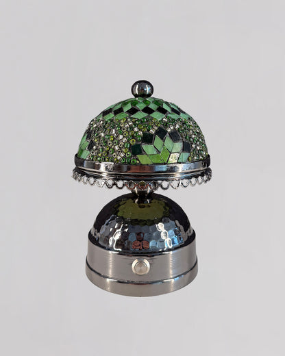 Decorative bell with green mosaic top and silver base on a white background