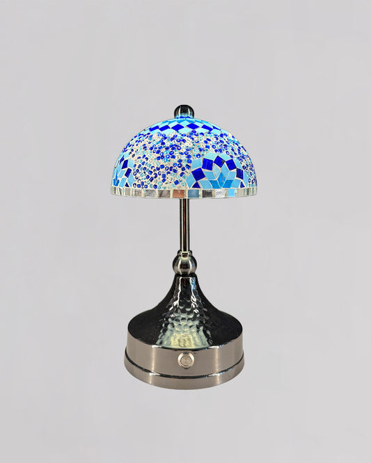 Decorative table lamp with a blue mosaic shade on a gray background